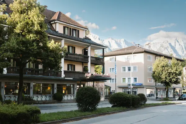 Garmisch-Partenkirchen Een gebouw met bomen en struiken langs de weg.