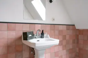 Badkamer in het HENRI in Garmisch-Partenkirchen Wastafel met daarboven een spiegel in de badkamer.