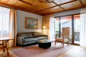 Suite in het HENRI in Garmisch-Partenkirchen Woonkamer met een bank en een salontafel.