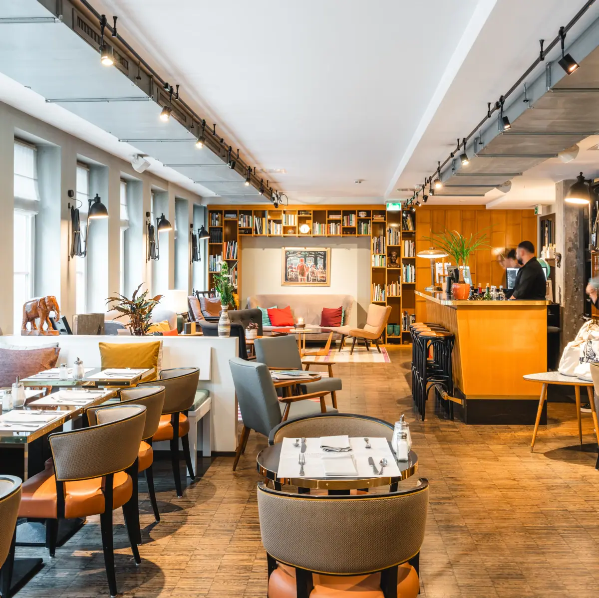Uitnodigende loungeruimte met veel tafels, stoelen en banken.