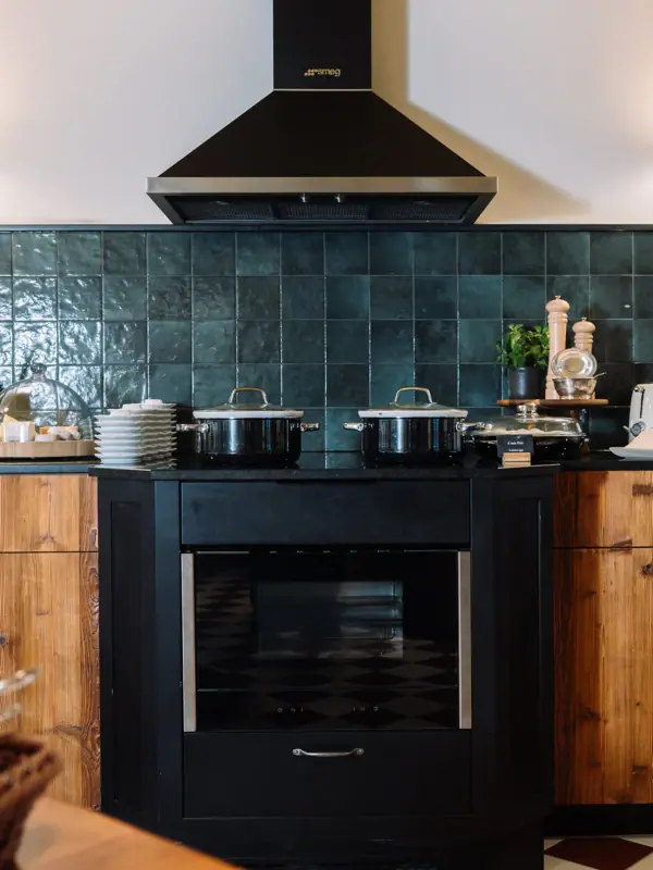 Een keuken met zwarte apparaten en een zwart fornuis.