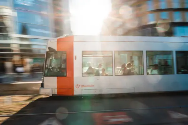 Düsseldorf-centrum Een wit-oranje bus op een weg.