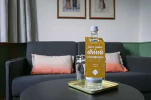 Uitschuifbare bank in HENRI Garmisch-Partenkirchen Een fles water op een dienblad.
