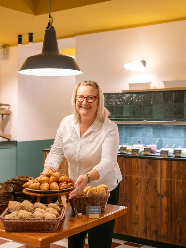 Een vrouw houdt een dienblad met eten in haar hand.