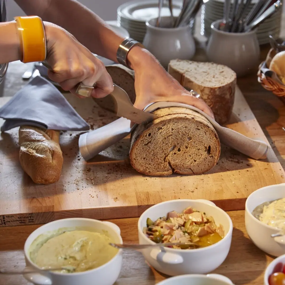 Iemand snijdt een brood in plakjes.