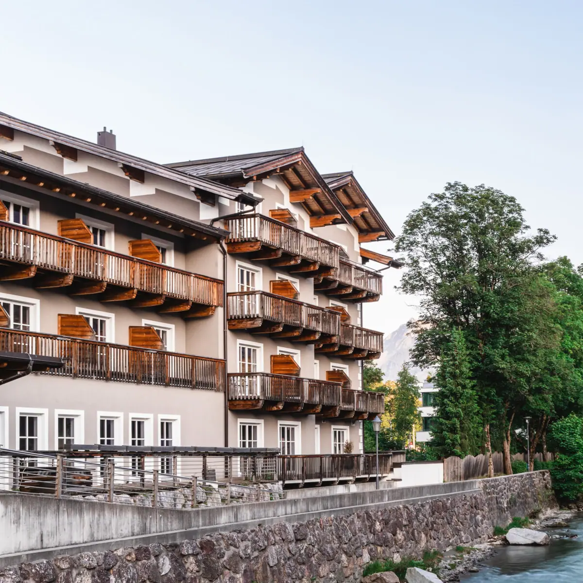 HENRI Hotel Kitzbühel aan de Tiroler Ache Een gebouw naast een rivier.