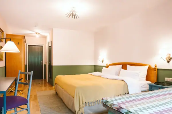 Een hotelkamer in het HENRI Hotel in Garmisch-Partenkirchen met een bed en een tafel.
