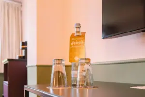 Een fles en glazen op een tafel.