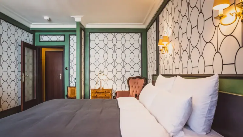 Kamer Een bed met kussens en een stoel in een kamer.