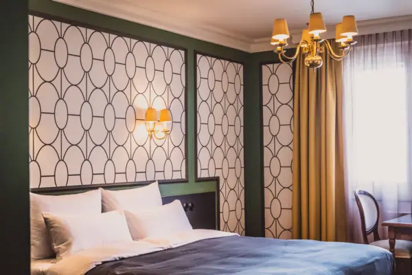 Een bed met een kroonluchter en gordijnen.