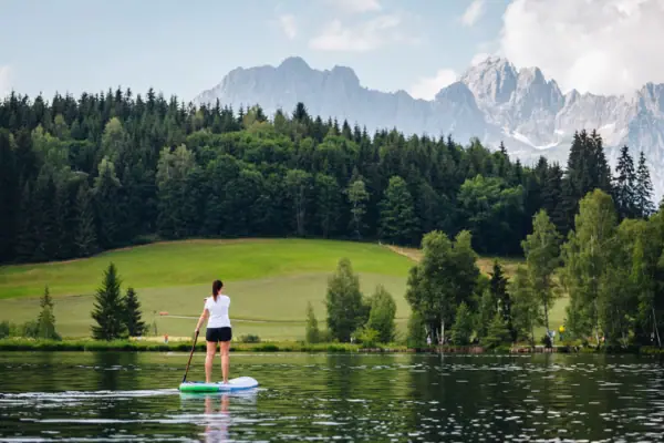 Een vrouw op een paddleboard op een meer.