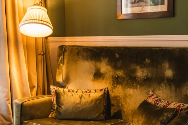 Een bank met kussens en een lamp in een kamer.