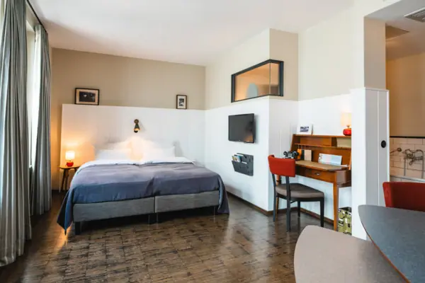 Een kamer met een bed en een bureau.