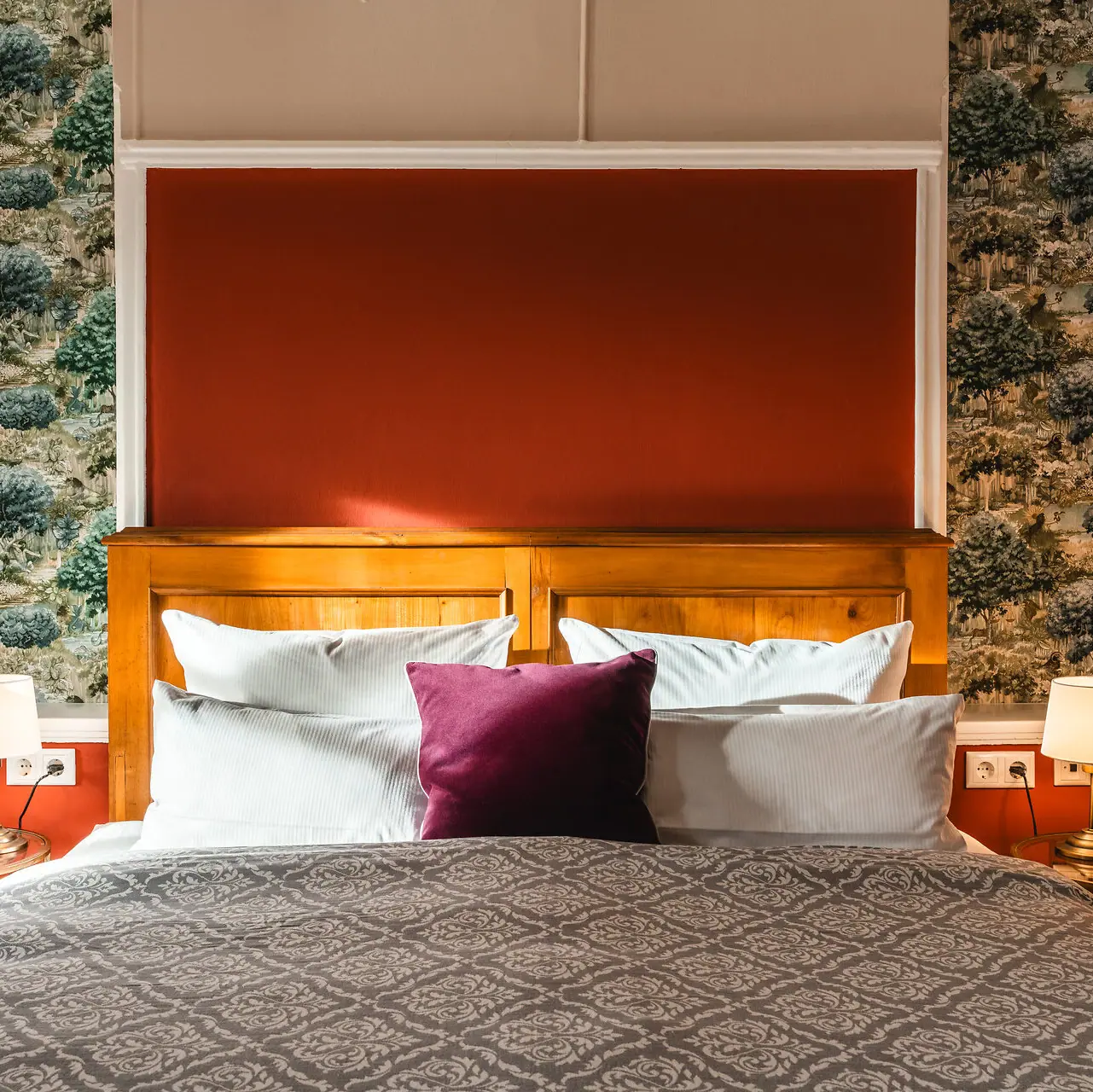 Een bed met een rood en wit kussen.