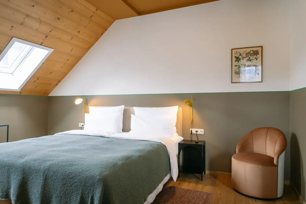 Een comfortabel bed in een stijlvol ingerichte kamer met kussens en beddengoed.
