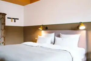 Een knus bed in een moderne hotelkamer in het HENRI Hotel Garmisch-Partenkirchen.