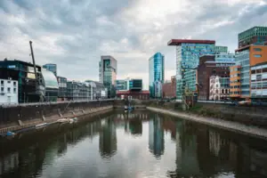 Rivier met gebouwen op de achtergrond en bewolkte lucht.
