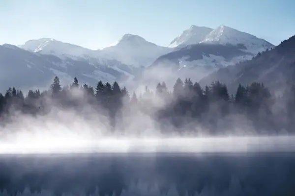 Kitzbühel Schwarzsee Een mistig meer met bergen op de achtergrond