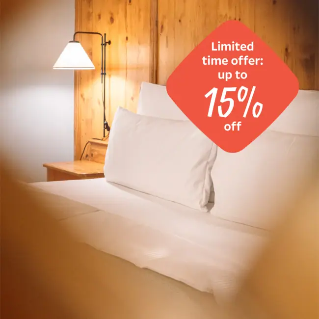 Herfstspecial Een bed met witte kussens en een lamp.