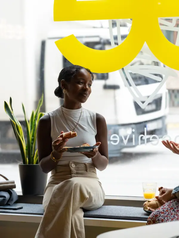 Bijenkorf Düsseldorf Een vrouw zit op een vensterbank en eet.