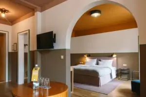 Hotelkamer in het HENRI Hotel Garmisch-Partenkirchen met een bed en een tv.