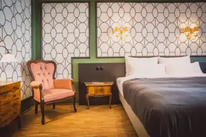 Slaapkamer met een bed en een stoel.