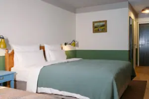 Slaapgedeelte in de salon Bed met een groene sprei en een lamp in de slaapkamer.