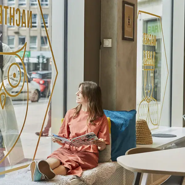 Een vrouw zit op een vensterbank.