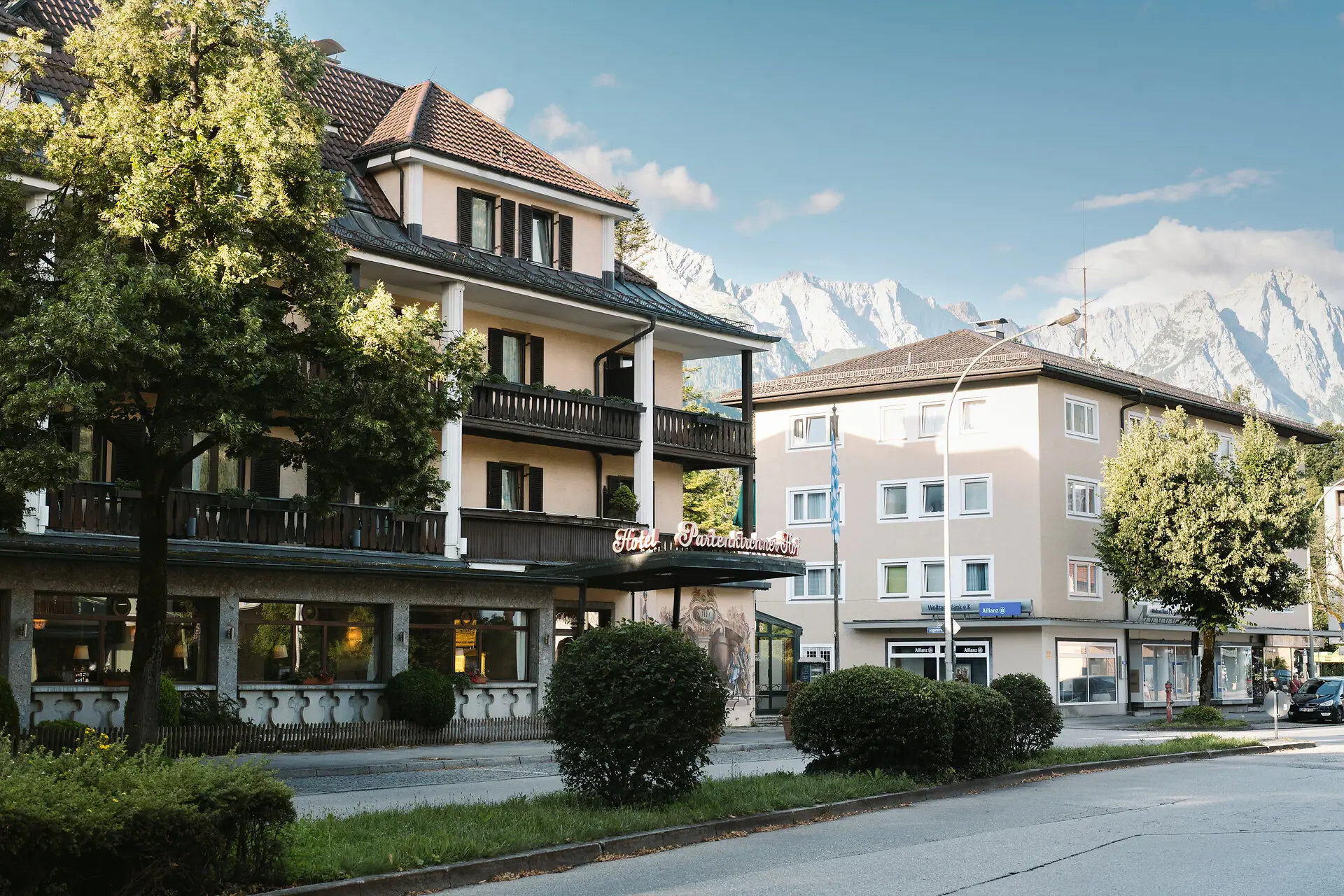 Buitenaanzicht van het HENRI Hotel Garmisch-Partenkirchen Buitenaanzicht van HENRI Hotel Garmisch-Partenkirchen met bomen en een weg.