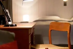 Een bureau met een lamp en een stoel.