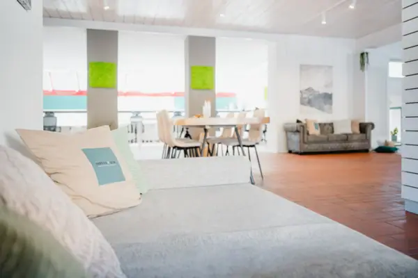 Bank in een kamer met kussens op een houten vloer.