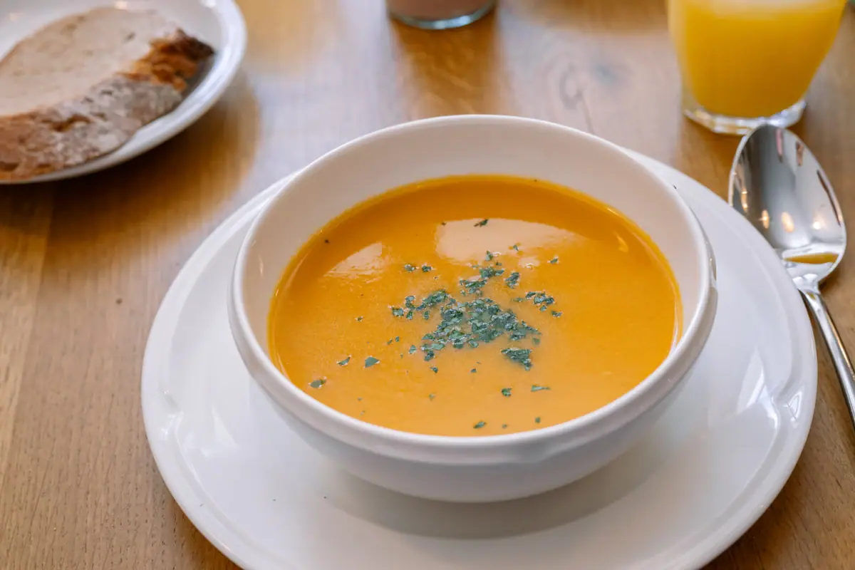 Een kom soep op een bord.