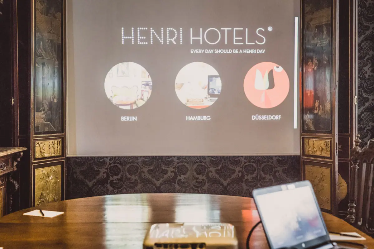 Projector op een houten tafel met een scherm ervoor