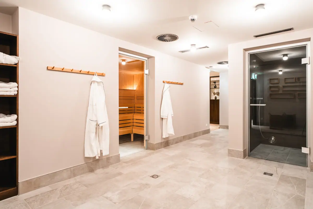 Een kamer met witte badjassen en een sauna.