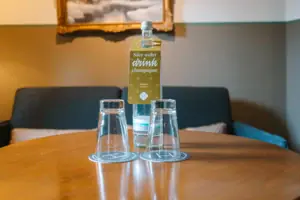 Waterfles en glazen in het HENRI Hotel Garmisch-Partenkirchen Een fles en glazen op een tafel in een hotelkamer in het HENRI Hotel Garmisch-Partenkirchen.