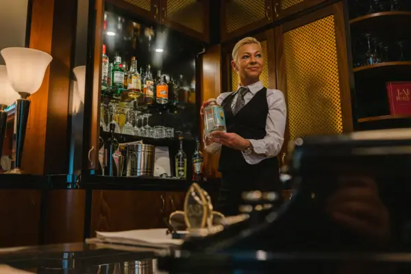 Een vrouw houdt een fles alcohol vast.
