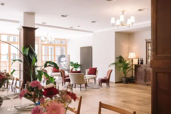 Evenementenruimte HENRI KIZ Een kamer met een tafel, stoelen en een vaas met bloemen.