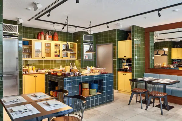 Een kamer met groene tegels en gele kasten.