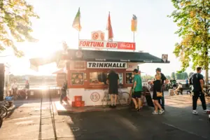 Düsseldorf Een klein wit en rood gebouw met mensen ervoor.