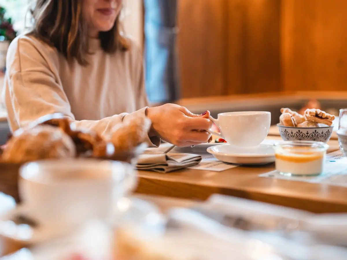 Tafel met ontbijt Een vrouw aan de ontbijttafel
