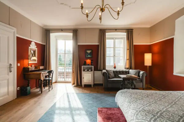 Hotelkamer HENRI Kitzbühel Een kamer met een bank en een bureau.