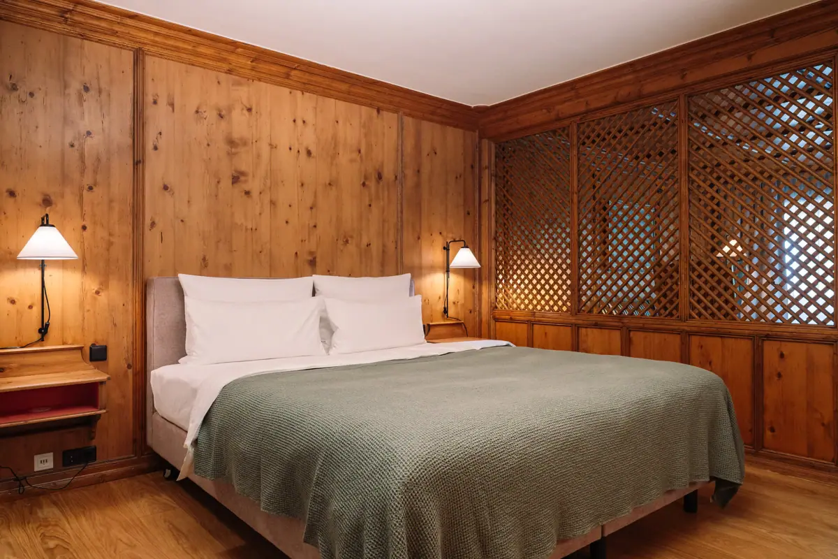 Een bed met een lamp in een kamer.