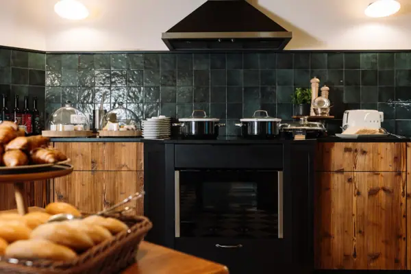 Een keuken met zwarte apparaten en een mand met brood.