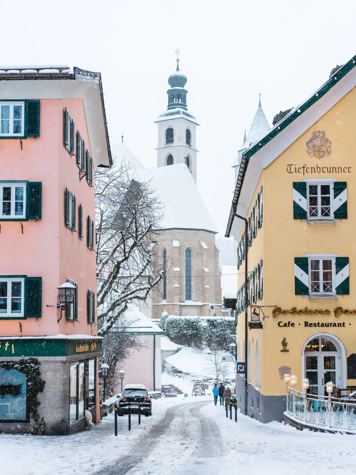 Oude binnenstad Kitzbühel Een groep gebouwen met sneeuw op de grond.