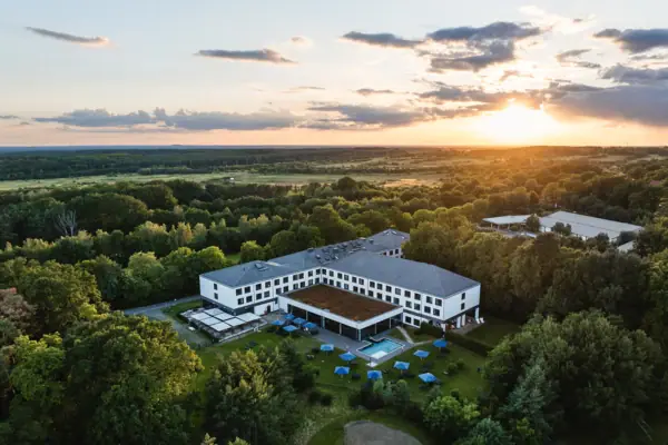 aja Bad Saarow Het aja Hotel in Bad Saarow met een zwembad omringd door bomen.
