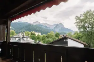 Balkon in het HENRI in Garmisch-Partenkirchen Uitzicht op bergen en bomen vanaf een balkon