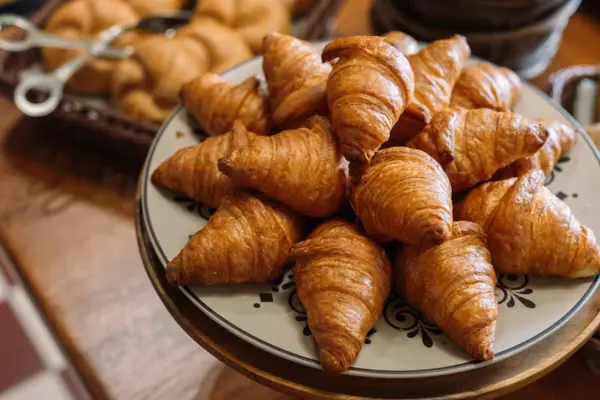 Een bord met croissants op een tafel.