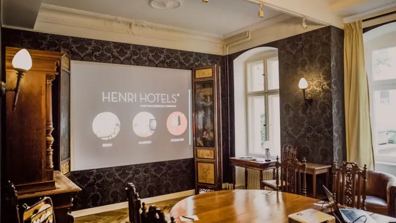 Een kamer met een projectiescherm en houten meubels.