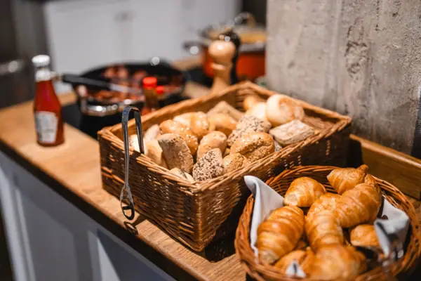 Manden met brood en croissants op een toonbank