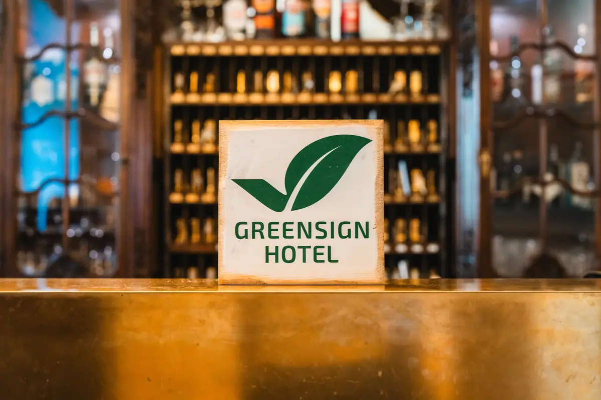 GreenSign Bord op een bar met flessen op de achtergrond.